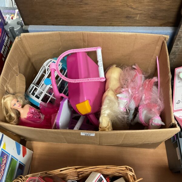 Box containing barbie dolls with a accessories and horses