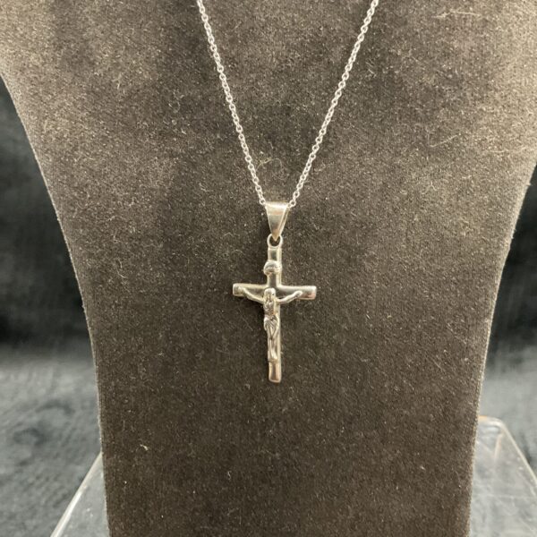 Silver crucifix necklace by Oliver Bonas on a chain.