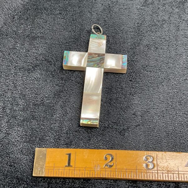 Antique mother of pearl cross pendant with iridescent shell.