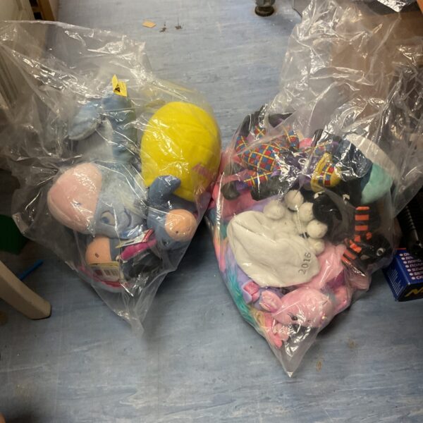 Mixed soft toys lot including Disney characters in plastic bags.
