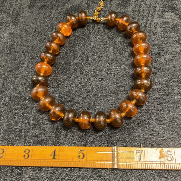 Close-up of vintage amber bead necklace with graduated beads.