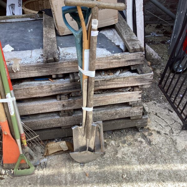 Selection of used garden tools including a spade and fork.