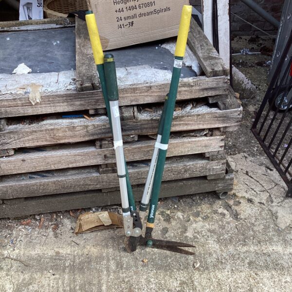 Pair of used garden clippers with green handles and silver blades.