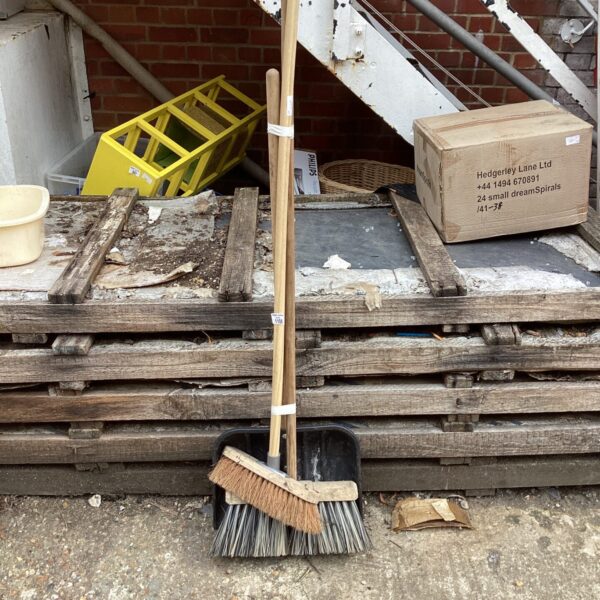 Vintage garden tools including a broom and shovel for outdoor maintenance.