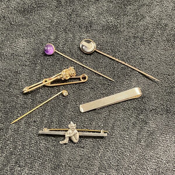 Vintage collection of tie pins and clips in silver and gold.