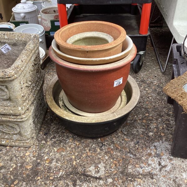 Stack of glazed terracotta garden pots for outdoor plants.
