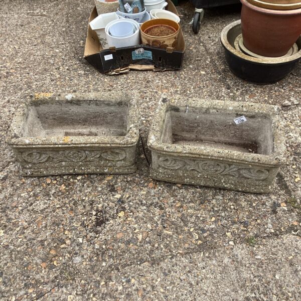 Pair of weathered stone effect garden planters for outdoor use.