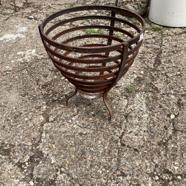 Vintage metal fire basket with tripod base for open fires.