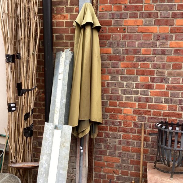 Large vintage garden parasol providing shade in a garden setting.