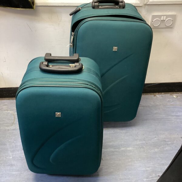 Pair of turquoise wheeled suitcases with extendable handles.