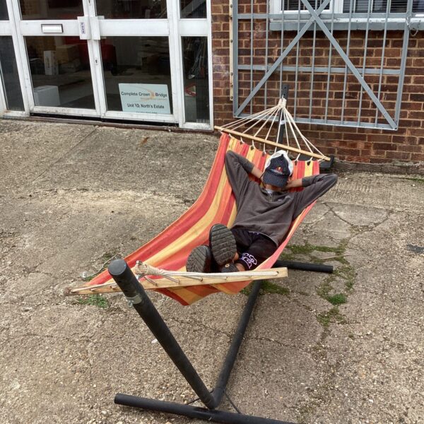 Folding garden hammock with metal frame for outdoor relaxation.