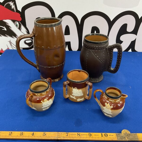 Antique Doulton salt glazed stoneware jugs with silver lips in a lot.