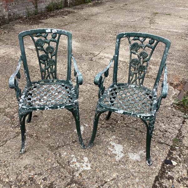 Ornate vintage metal garden chairs with floral detailing.