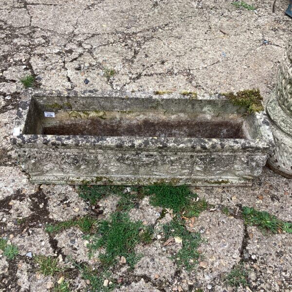 Weathered stone garden planter with greenery, ideal for outdoor display.