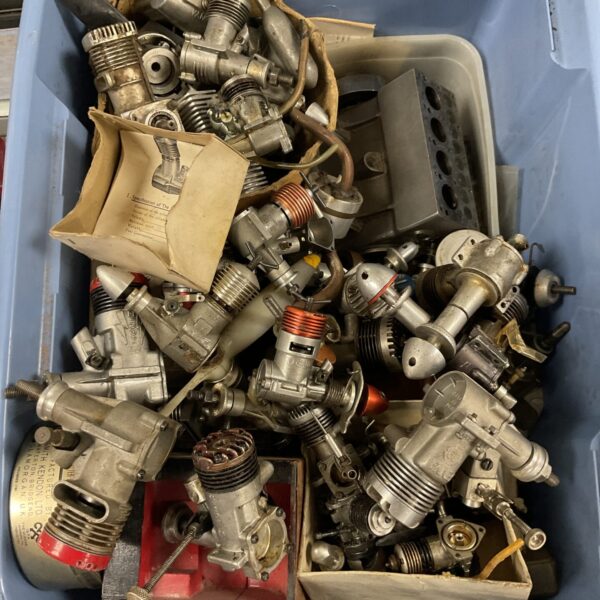 Assorted vintage model aircraft engines in a blue plastic container.