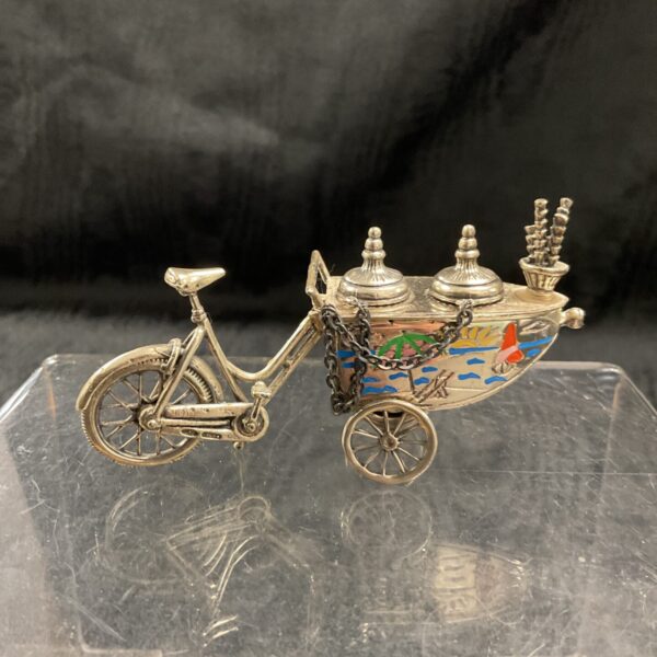 Detailed antique silver ice cream seller bicycle sculpture.