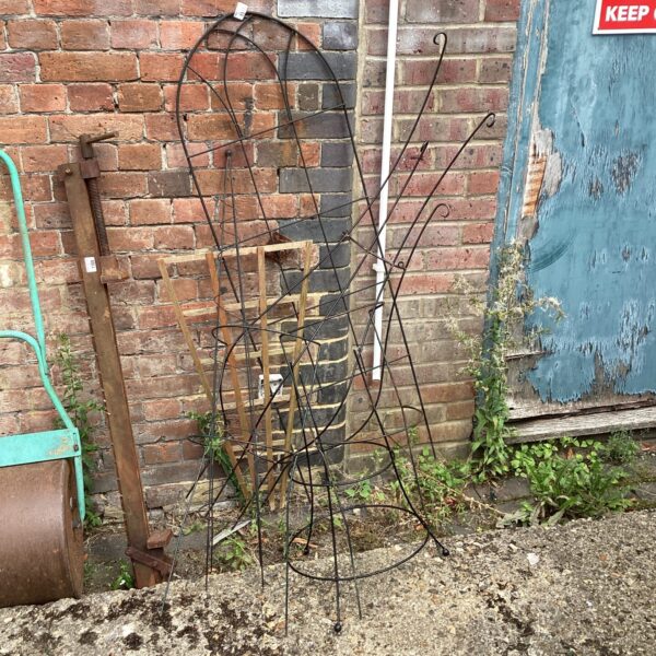Vintage metal plant frames in a garden setting.