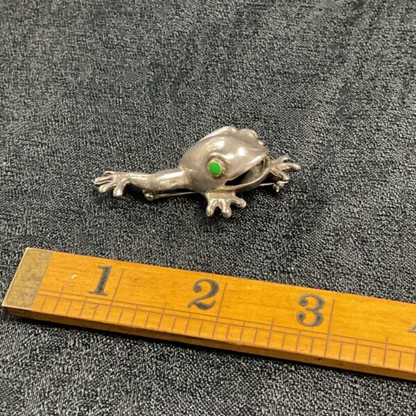 Detailed vintage sterling silver frog brooch, a charming collectible.