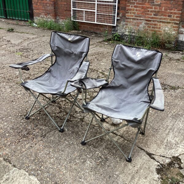 Pair of used folding camping chairs for outdoor use.
