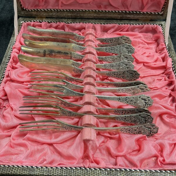 Boxed 800 silver dessert knife and fork set with embossed handles.