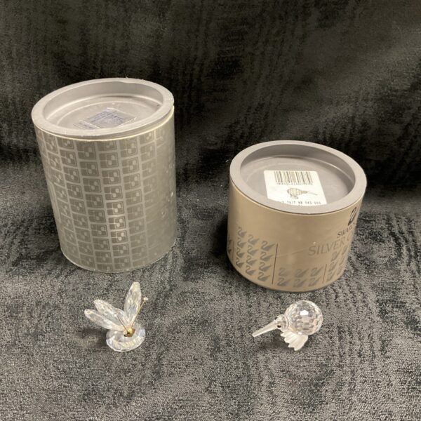 Swarovski crystal butterfly and kiwi figures in original packaging.