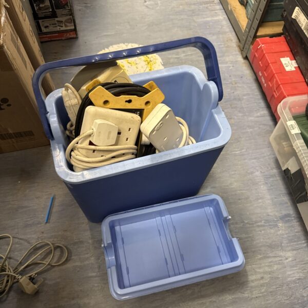 Blue cooler box filled with assorted extension leads and cables.