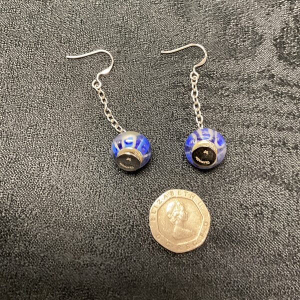 Close-up of Chamilia Murano glass earrings with blue and black swirl.