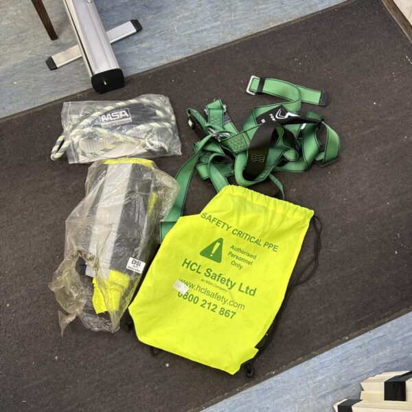 Climbing harness and high-visibility trousers for industrial safety.