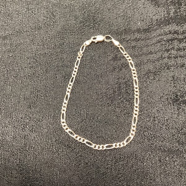 Close-up of a 925 silver Figaro chain bracelet.
