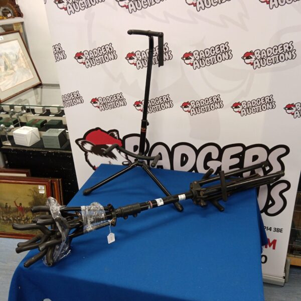 Two black collapsible guitar stands for musical instruments.