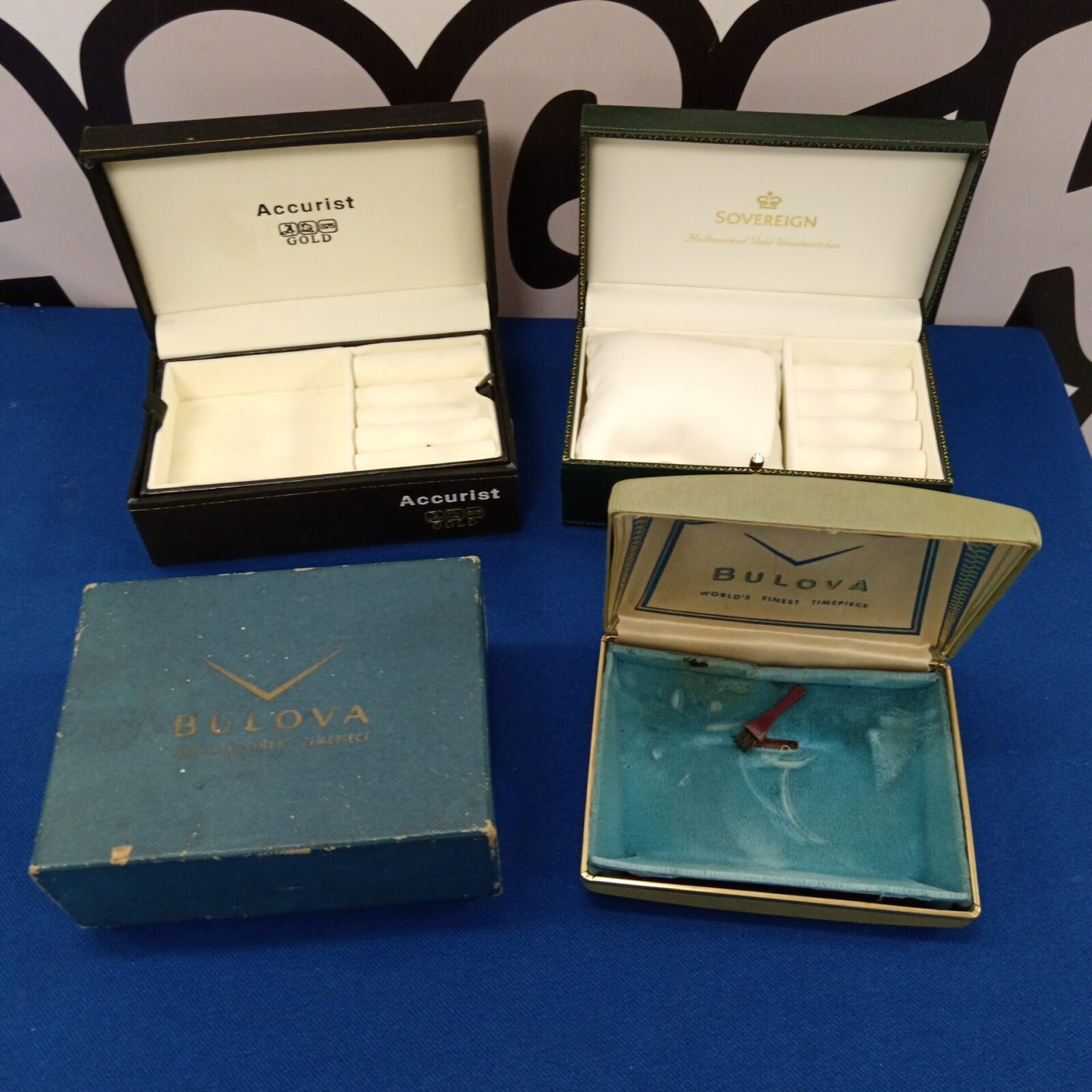 Three empty designer watch boxes including bulova, accurist & sovereign