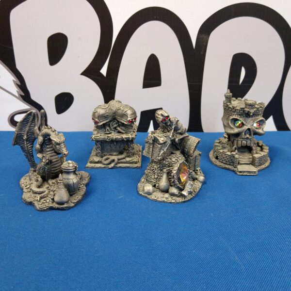 Lot of four pewter skulls and dragon figurines for collectors.