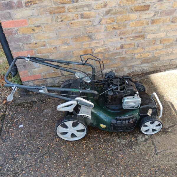 Used Webb Wrr21hw petrol lawn mower for garden maintenance.