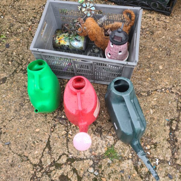 Mixed lot of vintage gardenware including watering cans and a dog planter.
