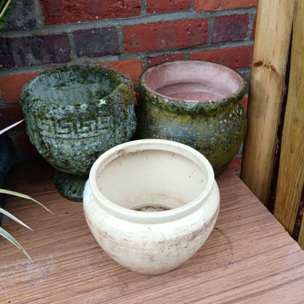 Lot of three weathered terracotta garden urn planters.