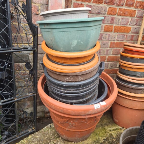 Stack of colourful plastic garden pots for outdoor plants.