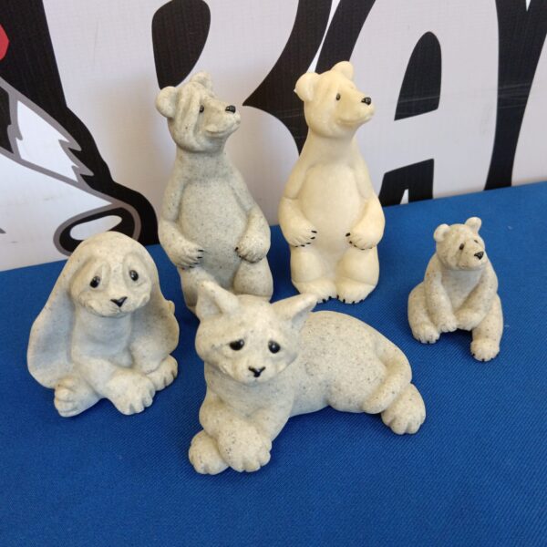 Set of four Quarry Critters animal ornaments on a blue background.