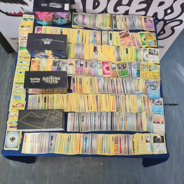 Large lot of mixed Pokemon trading cards with holographic examples.