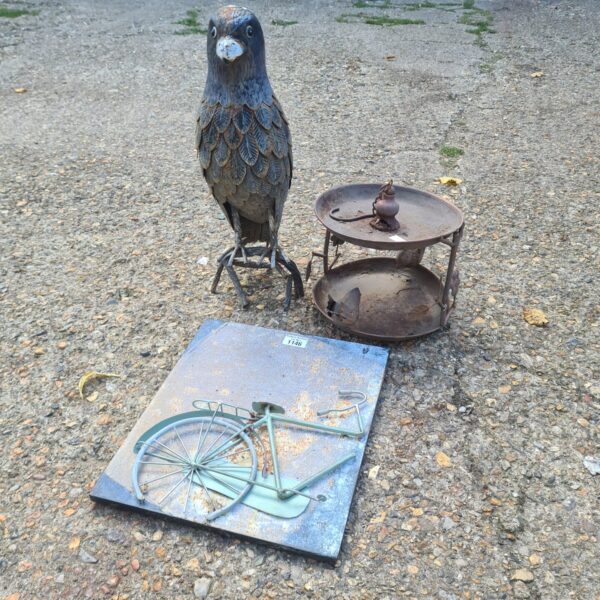 Metal garden ornaments featuring a bird sculpture and tiered stand.