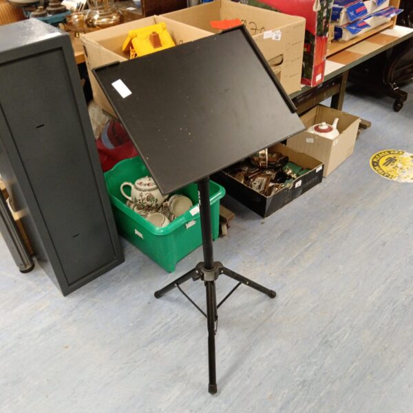 Black metal tripod music stand for sheet music.
