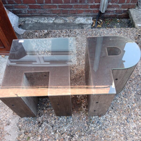 Vintage H-shaped coffee table with glass top and wooden base.