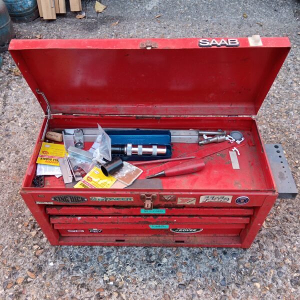 Red metal toolbox with various tools and items inside.