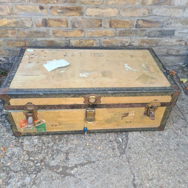 Antique steamer trunk with visible wear and tear.