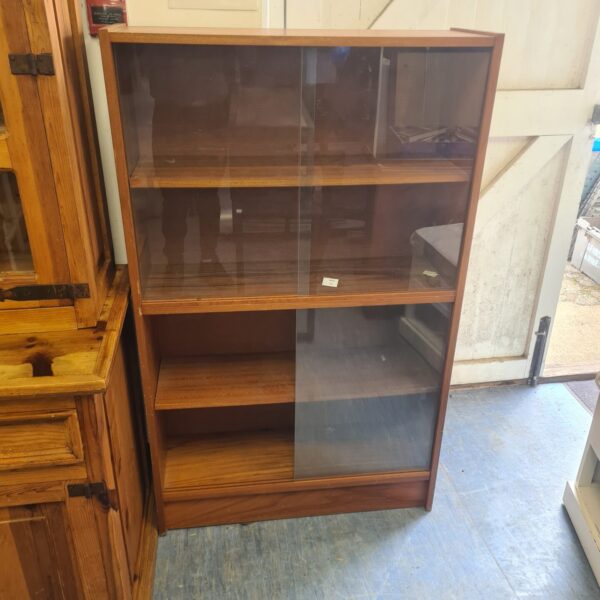 Vintage wooden display cabinet with glass front for collectibles.