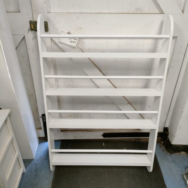 White wooden bottle and jar shelving unit for kitchen storage.
