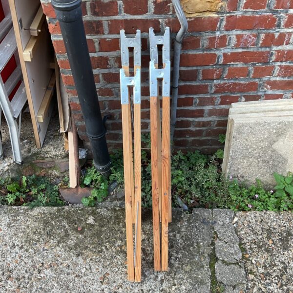 Vintage wooden folding trestle legs for table support.