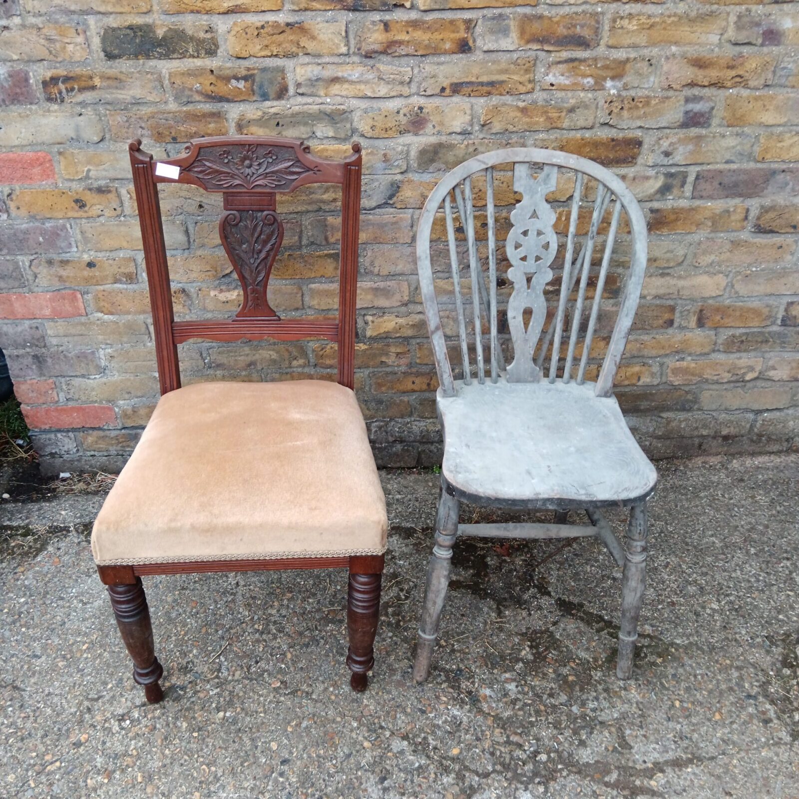 Front view of antique wheelback chair with a worn seat.