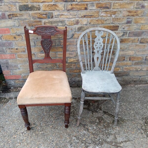 Front view of antique wheelback chair with a worn seat.