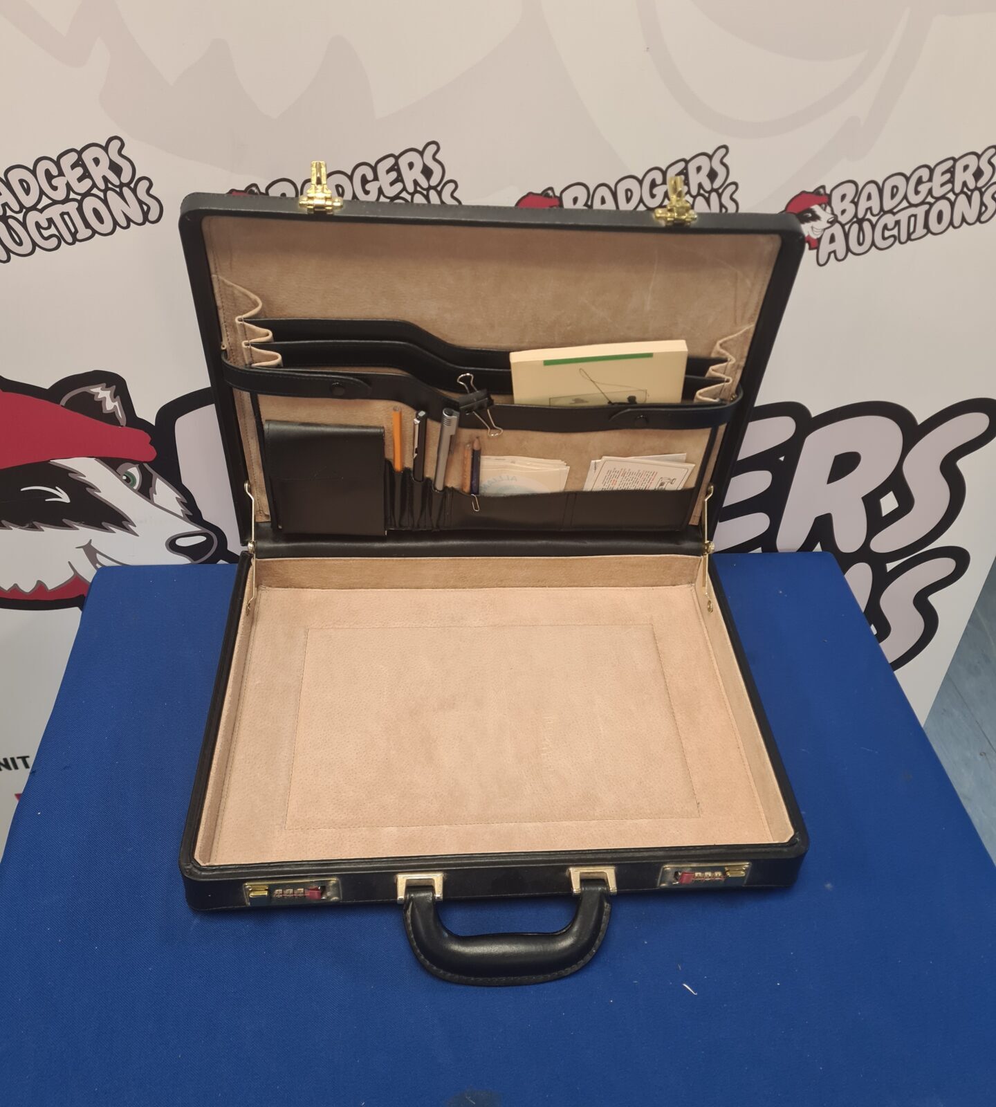 Vintage black leather briefcase with contents open.
