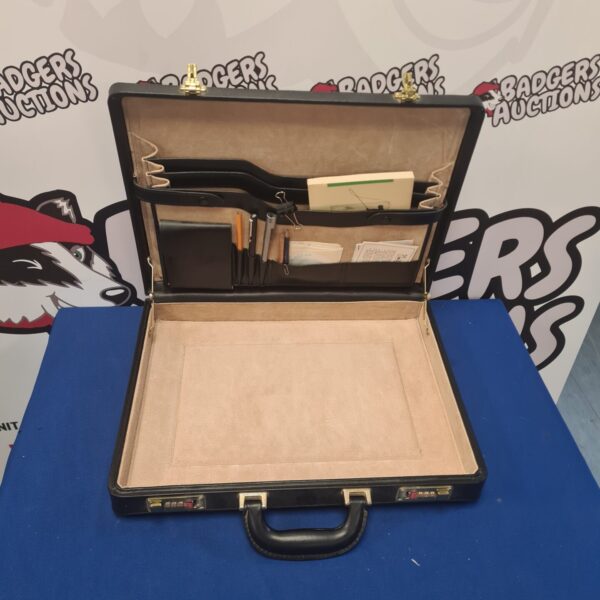 Vintage black leather briefcase with contents open.